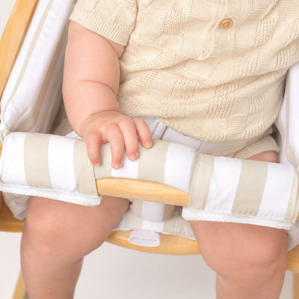 Close-up of a baby hand on the padded Little Sonny seat bar with the fastening buckle